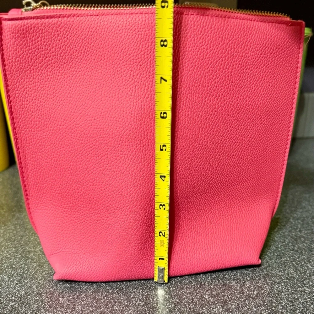 Pink cosmetics bag with 🐝 emblem. Has two inside pockets.